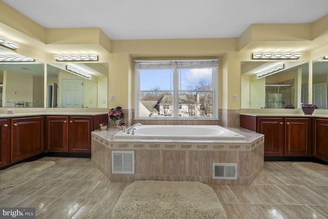 bathroom featuring tile patterned floors, tiled tub, and vanity