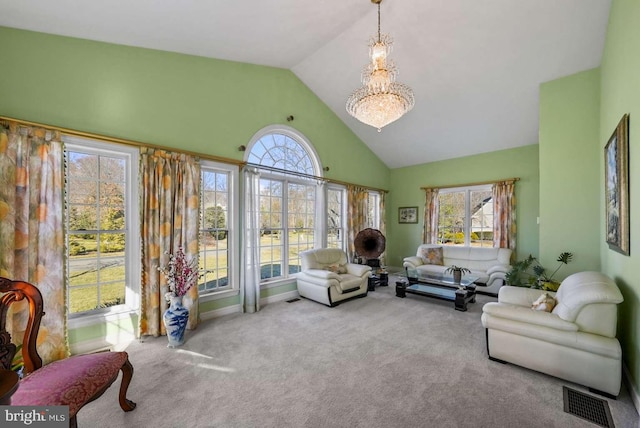 carpeted living room featuring high vaulted ceiling, a wealth of natural light, and a chandelier