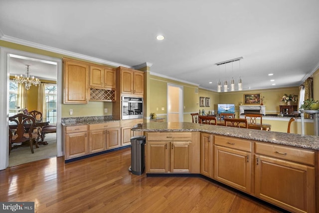 kitchen featuring hanging light fixtures, a chandelier, crown molding, and oven