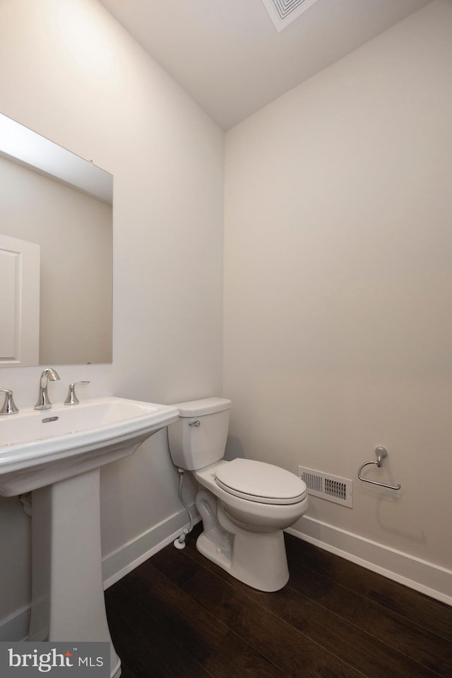 bathroom with sink, hardwood / wood-style floors, and toilet