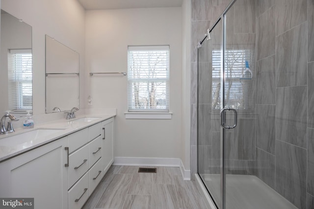 bathroom featuring an enclosed shower, vanity, and plenty of natural light