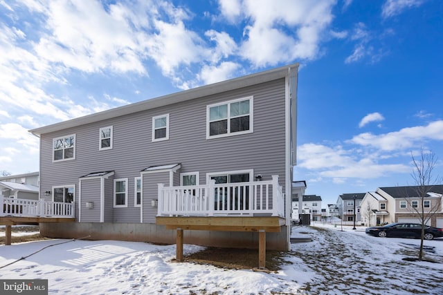 snow covered house with a deck