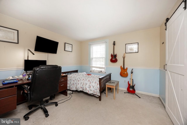 carpeted bedroom featuring a barn door