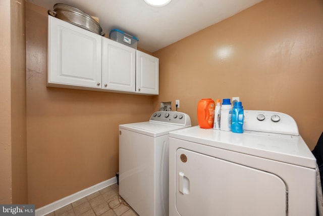 laundry area with washer and clothes dryer and cabinets