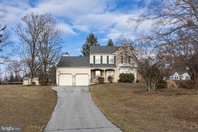 view of front of house with a garage, a front yard, and a storage unit