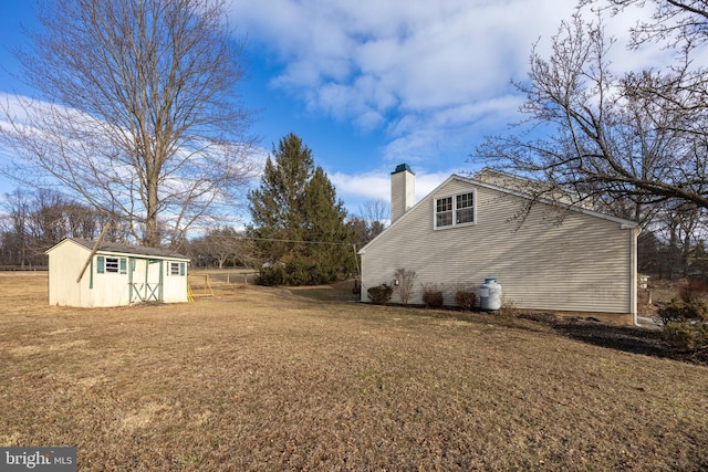 view of home's exterior with a storage unit and a yard