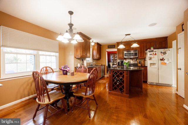 dining space with dark wood-type flooring and an inviting chandelier