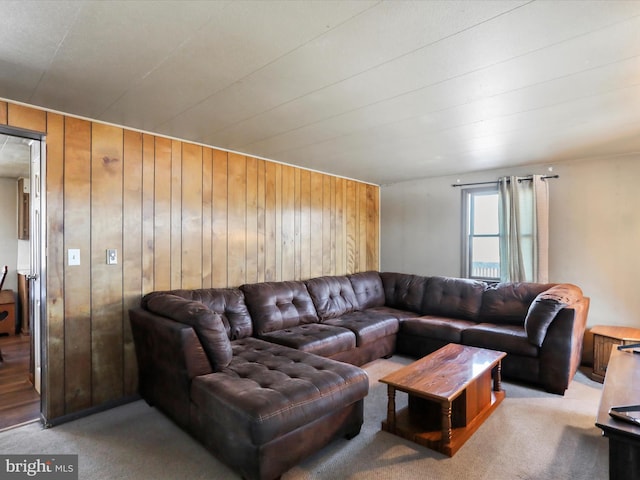 carpeted living room featuring wood walls