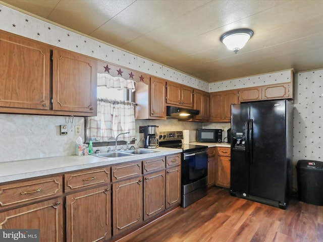 kitchen with sink, dark hardwood / wood-style flooring, and black appliances