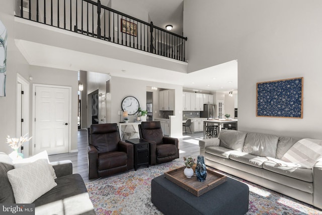 living room with light hardwood / wood-style floors and a high ceiling