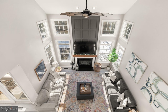 living room featuring ceiling fan and a towering ceiling