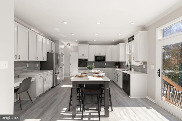 kitchen with sink, crown molding, white cabinets, and appliances with stainless steel finishes