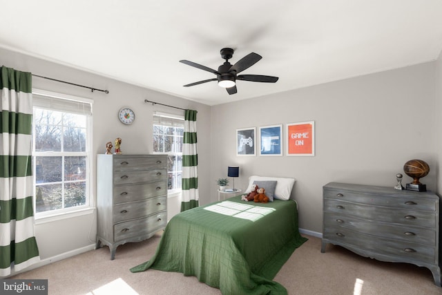 carpeted bedroom featuring ceiling fan and multiple windows