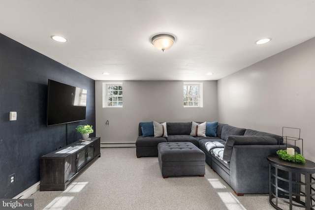 living room with a baseboard heating unit and light colored carpet