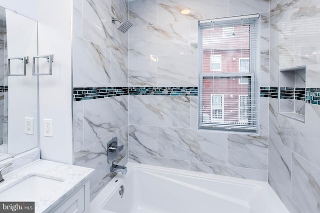 bathroom featuring tiled shower / bath and vanity