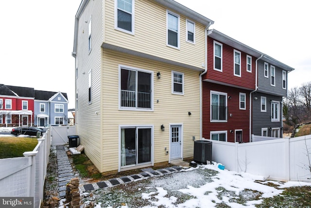 snow covered house featuring central AC