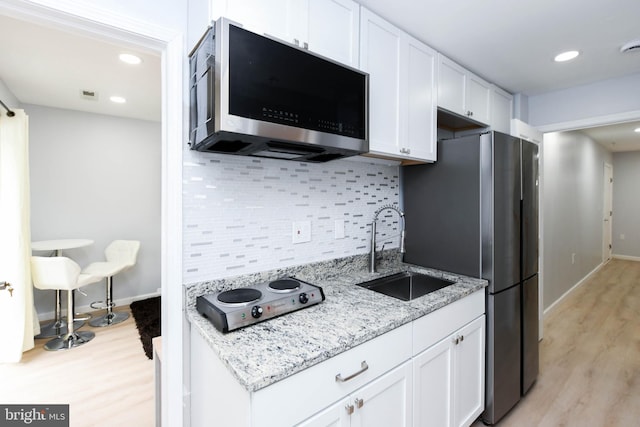 kitchen featuring white cabinets, backsplash, sink, and stainless steel appliances