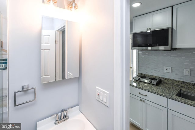 bathroom featuring vanity and backsplash