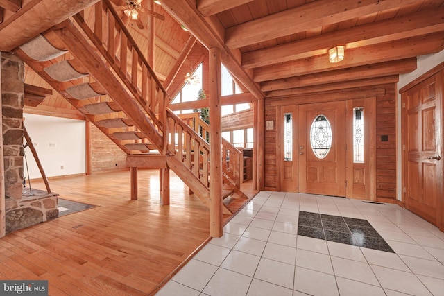 tiled foyer featuring ceiling fan, wooden ceiling, and beamed ceiling