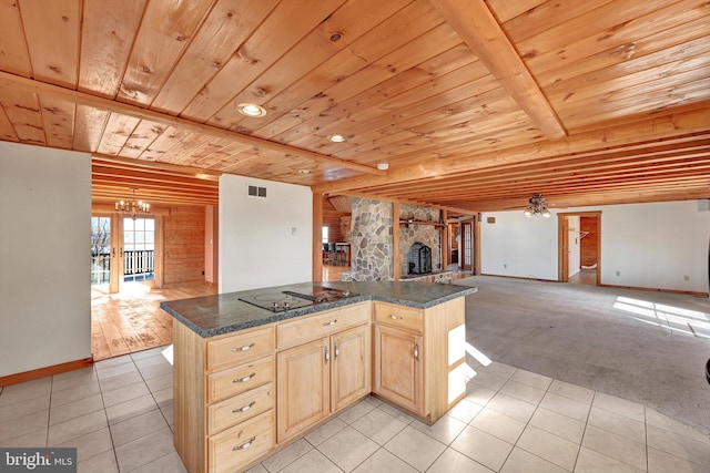 kitchen featuring light carpet, ceiling fan, dark stone countertops, and light brown cabinets