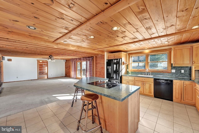 kitchen with a kitchen island, black appliances, sink, light carpet, and light brown cabinetry