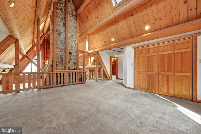 unfurnished living room featuring carpet floors, wooden ceiling, beamed ceiling, and high vaulted ceiling