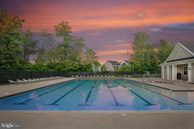 pool at dusk featuring a patio area