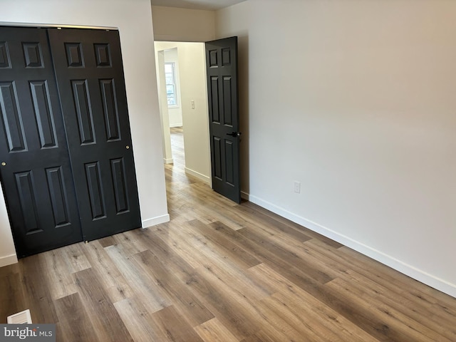 unfurnished bedroom with a closet and light hardwood / wood-style floors