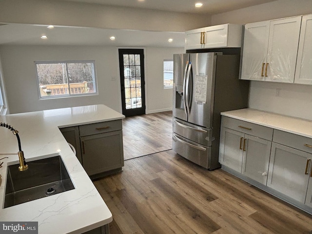 kitchen with dark hardwood / wood-style floors, light stone countertops, stainless steel fridge with ice dispenser, gray cabinetry, and white cabinets