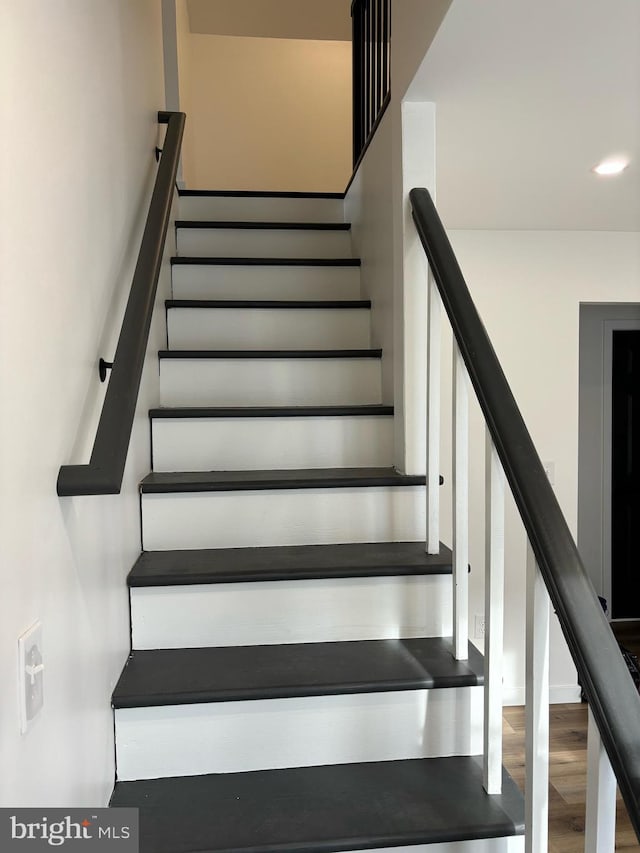 staircase with hardwood / wood-style floors