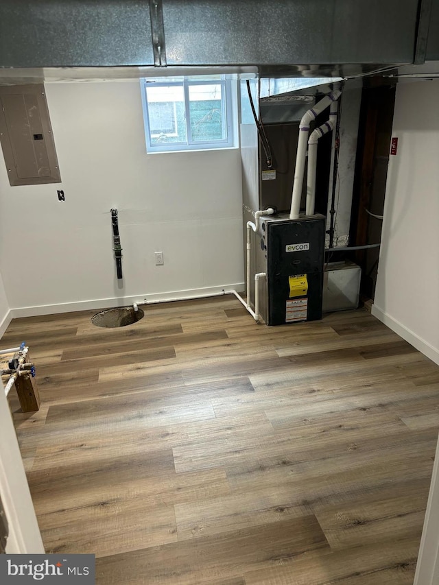 utility room with electric panel and heating unit