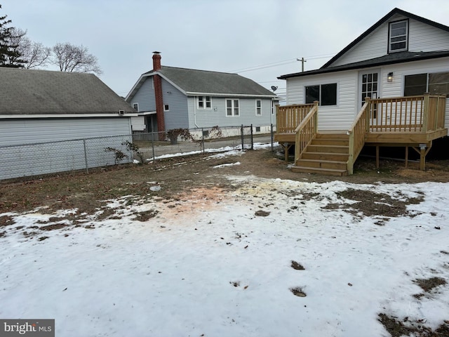 snow covered rear of property featuring a deck