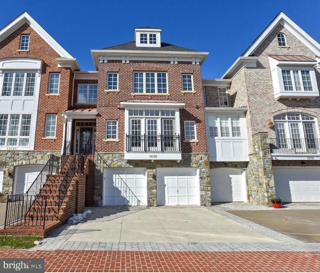 view of front of house featuring a garage, brick siding, stone siding, and driveway