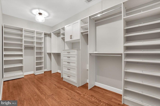 walk in closet with wood finished floors