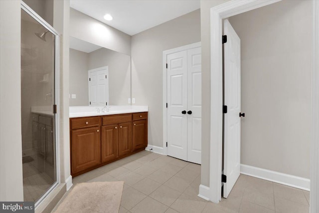 full bath with vanity, a shower stall, baseboards, and tile patterned flooring