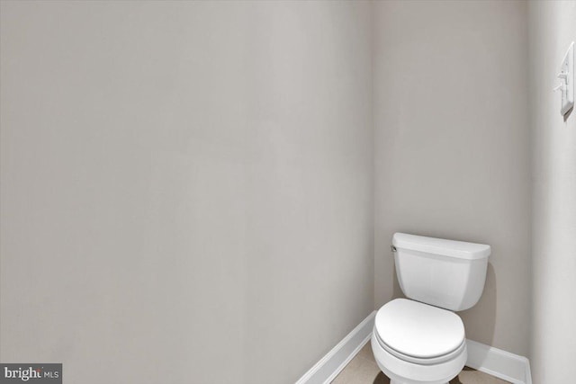 bathroom with tile patterned floors, toilet, and baseboards