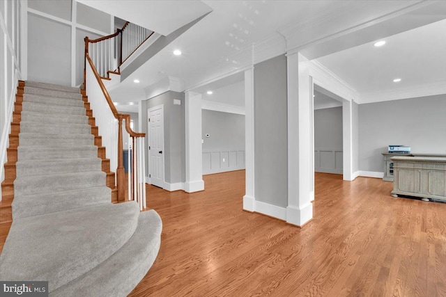 entryway featuring stairway, ornamental molding, and wood finished floors