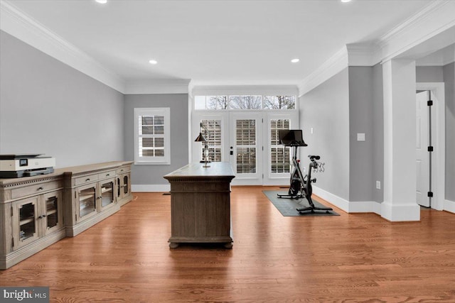 exercise room with baseboards, wood finished floors, and crown molding