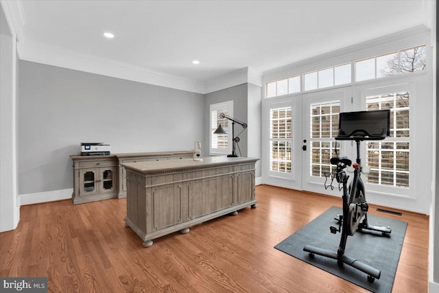 workout area with light wood finished floors, visible vents, french doors, and ornamental molding