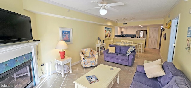 tiled living room featuring a textured ceiling, ceiling fan, track lighting, and crown molding