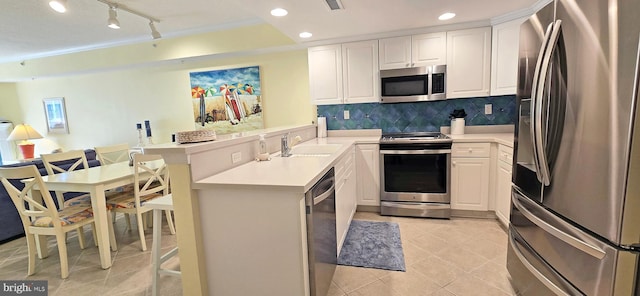 kitchen featuring sink, white cabinetry, appliances with stainless steel finishes, and kitchen peninsula