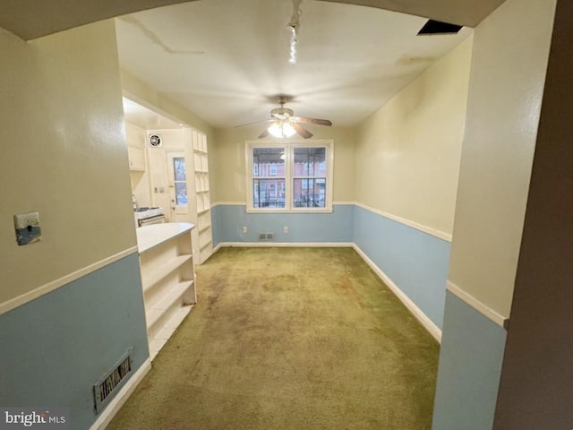 empty room featuring ceiling fan and light colored carpet