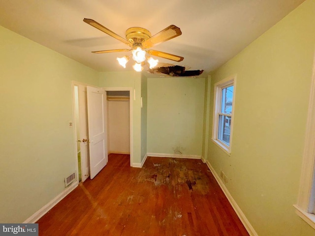 unfurnished bedroom featuring dark wood-type flooring, ceiling fan, and a closet