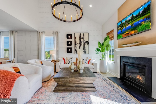 living room with plenty of natural light, lofted ceiling, and a notable chandelier