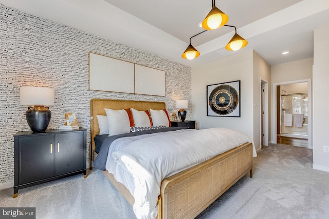 bedroom featuring connected bathroom and light colored carpet