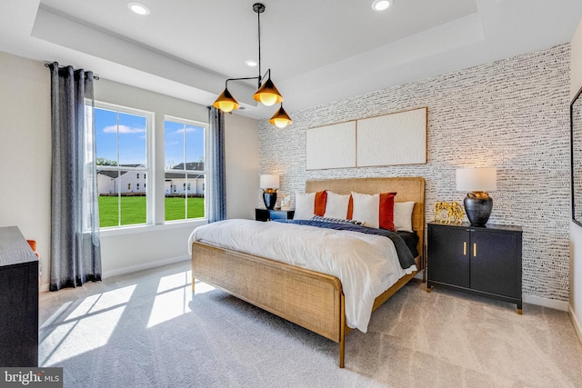 carpeted bedroom featuring a raised ceiling