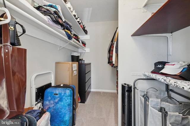 walk in closet featuring light colored carpet