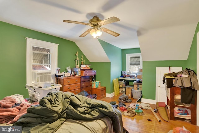 bedroom featuring ceiling fan, cooling unit, light hardwood / wood-style flooring, and vaulted ceiling