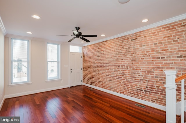 interior space featuring ceiling fan, ornamental molding, brick wall, and dark hardwood / wood-style floors