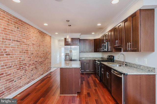 kitchen featuring brick wall, sink, hanging light fixtures, a center island, and stainless steel appliances